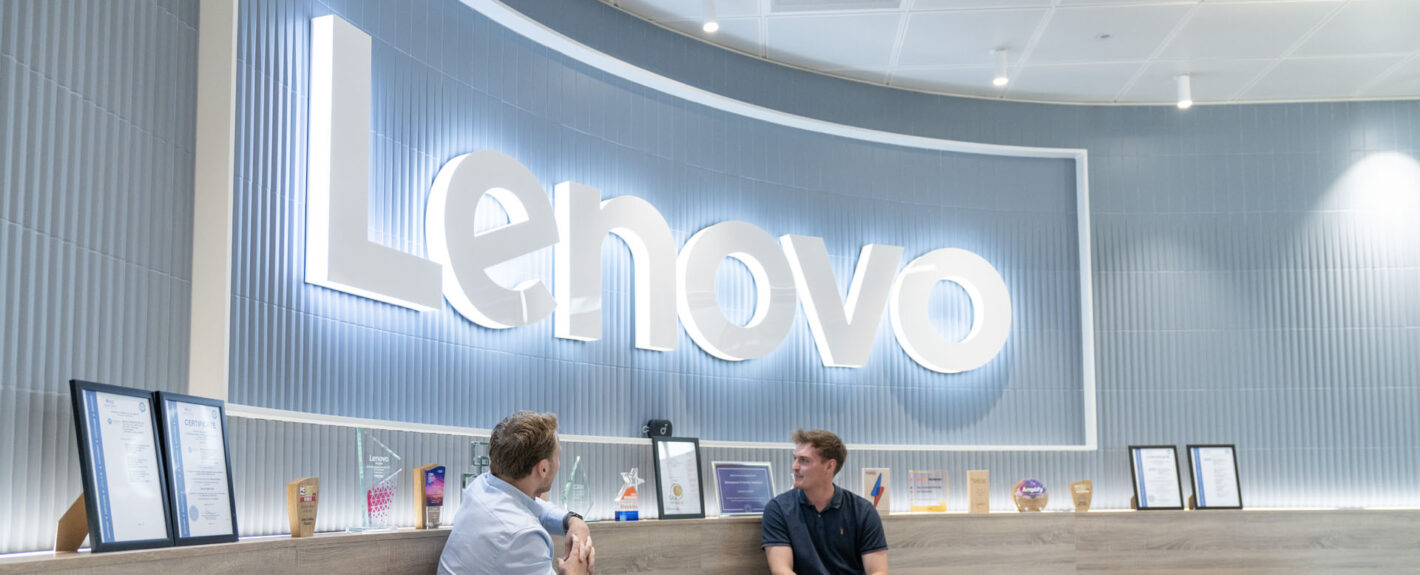 Lenovo signage with two people sitting in front of it